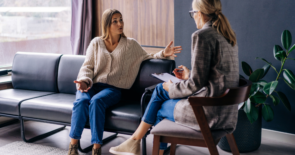 Therapist and client talking in a calm, plant-filled office